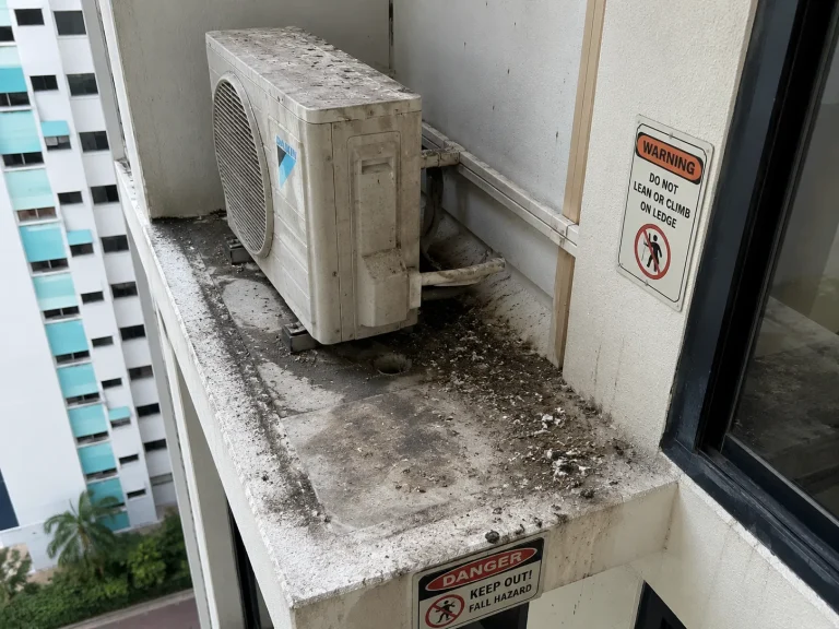 HDB aircon ledge in Singapore showing visible bird droppings and debris buildup on outdoor condenser unit — signs that professional ledge cleaning is needed