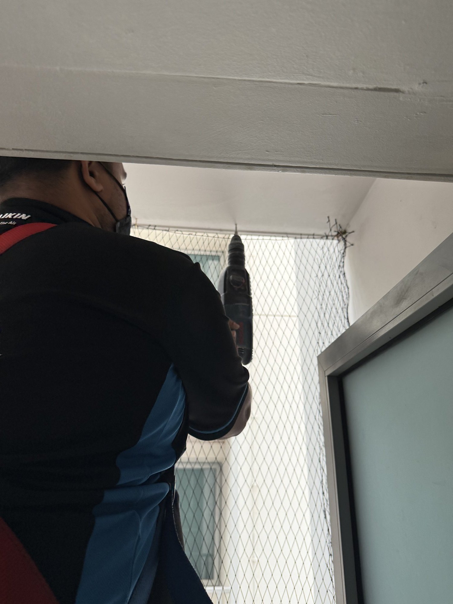 UV-stabilised HDPE bird netting professionally installed on HDB aircon ledge in Singapore by Coogle Aircon — black mesh fully covering outdoor condenser unit